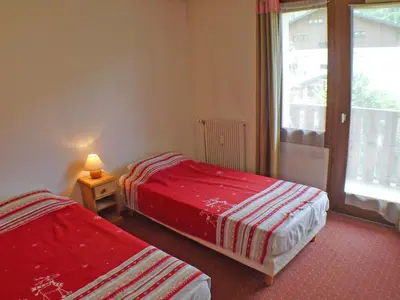 two beds in a room with a window at T2 calme à Samoëns - 4 pers, animaux admis - FR-1-629-70 in Samoëns