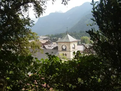 a building with a clock tower in the middle of a town at T2 calme à Samoëns - 4 pers, animaux admis - FR-1-629-70 in Samoëns