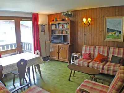 a living room with a table and a couch at Duplex 4 pièces avec balcon et Wifi à Samoëns pour 8 pers - FR-1-629-3 in Samoëns