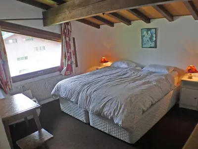 a bedroom with a large bed and a window at Duplex 4 pièces avec balcon et Wifi à Samoëns pour 8 pers - FR-1-629-3 in Samoëns