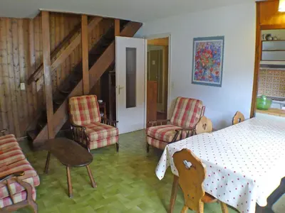 a room with a table and chairs and a staircase at Duplex 4 pièces avec balcon et Wifi à Samoëns pour 8 pers - FR-1-629-3 in Samoëns