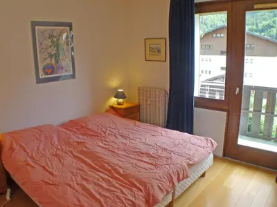 a bedroom with a bed and a door to a balcony at Duplex 4 pièces avec balcon et Wifi à Samoëns pour 8 pers - FR-1-629-3 in Samoëns
