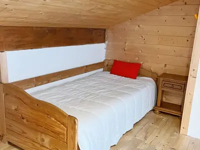 a bedroom with a bed with a red pillow on it at Chalet au centre de Samoëns avec jardin et cheminée - FR-1-624-17 in Samoëns