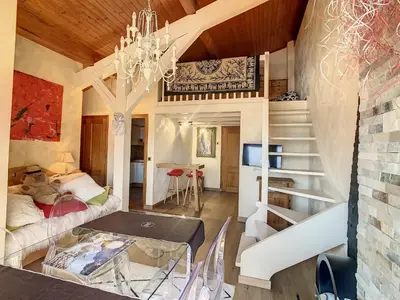 a living room with a staircase and a table at 2 pièces + mezzanine au pied des pistes à Combloux - FR-1-560-73 in Combloux