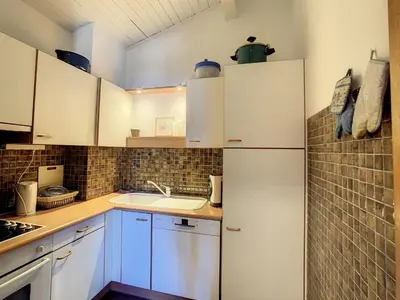 a kitchen with white cabinets and a sink at 2 pièces + mezzanine au pied des pistes à Combloux - FR-1-560-73 in Combloux