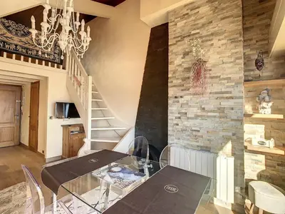 a dining room with a glass table and a stone wall at 2 pièces + mezzanine au pied des pistes à Combloux - FR-1-560-73 in Combloux