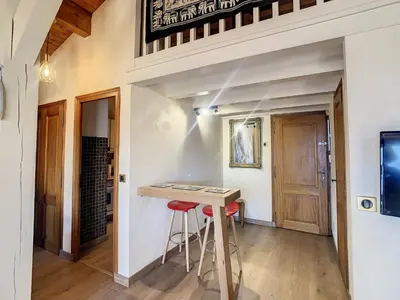 a kitchen with a table and stools in a room at 2 pièces + mezzanine au pied des pistes à Combloux - FR-1-560-73 in Combloux
