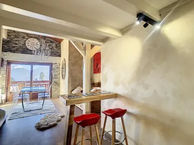 a room with a table and two red stools at 2 pièces + mezzanine au pied des pistes à Combloux - FR-1-560-73 in Combloux