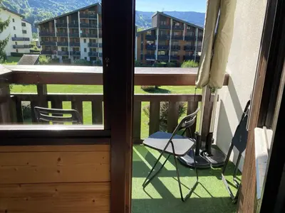 a balcony with a chair and a view of a building at Studio moderne avec balcon et parking dans Samoëns - FR-1-624-71 in Samoëns