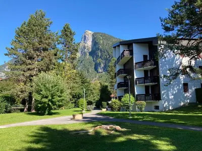 a apartment building with a mountain in the background at Studio moderne avec balcon et parking dans Samoëns - FR-1-624-71 in Samoëns