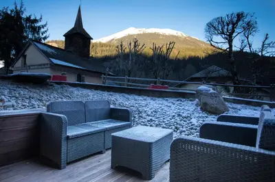 a patio with chairs and a snow covered mountain at Chalet Grand Balcon in Les Houches