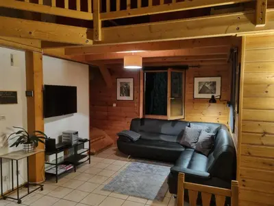 a living room with a leather couch and a television at Chalet Tontine, 3 bedrooms, sauna, terrace and great views ! in Les Houches