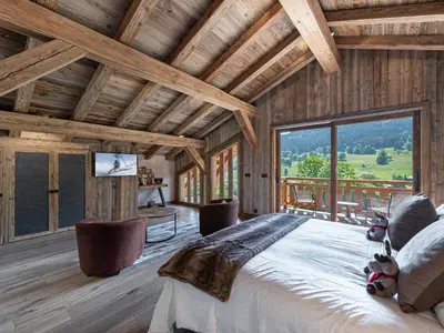a bedroom with a large bed and a large window at Chalet Luxe 12 Pers. Face aux Pistes avec Skiroom, Garage, Salle de Sport et Services Inclus - FR-1-569-19 in Demi-Quartier