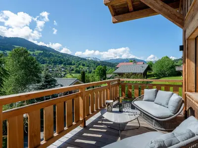 a deck with a couch and a table on a balcony at Chalet Luxe 12 Pers. Face aux Pistes avec Skiroom, Garage, Salle de Sport et Services Inclus - FR-1-569-19 in Demi-Quartier