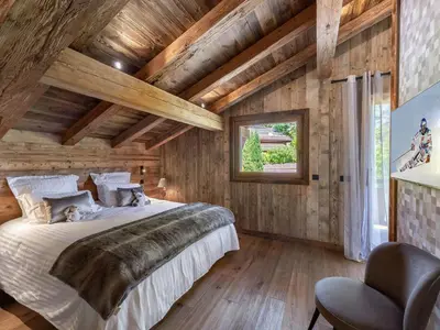 a bedroom with a large bed and wooden ceilings at Chalet Luxe 12 Pers. Face aux Pistes avec Skiroom, Garage, Salle de Sport et Services Inclus - FR-1-569-19 in Demi-Quartier