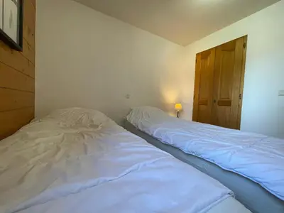 a bedroom with two white beds and a window at Appartement T3 au centre de Samoëns avec balcon, WIFI et parking - FR-1-624-23 in Samoëns