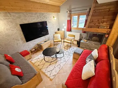 a living room with a red couch and a tv at Appartement duplex spacieux avec piscine et WiFi à Samoëns - FR-1-624-9 in Samoëns