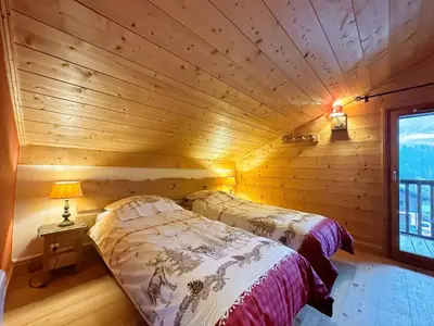 a bedroom with two beds in a log cabin at Appartement duplex spacieux avec piscine et WiFi à Samoëns - FR-1-624-9 in Samoëns