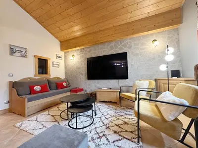 a living room with a couch and a tv at Appartement duplex spacieux avec piscine et WiFi à Samoëns - FR-1-624-9 in Samoëns