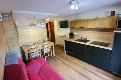 a living room with a couch and a kitchen at Appartement l'Edel - Vue Massif Mont-Blanc in Saint-Gervais-les-Bains