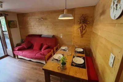 a living room with a red couch and a table at Appartement l'Edel - Vue Massif Mont-Blanc in Saint-Gervais-les-Bains
