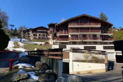 a large building in front of a river at Appartement l'Edel - Vue Massif Mont-Blanc in Saint-Gervais-les-Bains