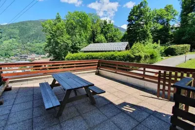 a wooden picnic table sitting on top of a roof at Appartement l'Edel - Vue Massif Mont-Blanc in Saint-Gervais-les-Bains