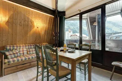 a dining room with a table and chairs and a couch at Apartment Lachenal - Alpes Travel - Alpes Travel - Central Chamonix - sleeps 2-4 in Chamonix-Mont-Blanc