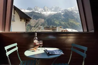 a table with two chairs and a window with a view at Apartment Lachenal - Alpes Travel - Alpes Travel - Central Chamonix - sleeps 2-4 in Chamonix-Mont-Blanc