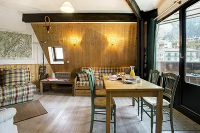 a dining room with a wooden table and chairs at Apartment Lachenal - Alpes Travel - Alpes Travel - Central Chamonix - sleeps 2-4 in Chamonix-Mont-Blanc