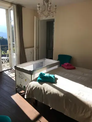 a bedroom with a large bed and a chandelier at onlysaintg - Apartment Bernadette Spacious 4 bedrooms Great views, 120 m2 Only 500m from the centre and ski lift GREAT YEAR ROUND in Saint-Gervais-les-Bains