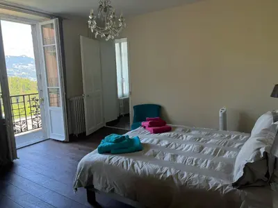 a bedroom with a bed and a chandelier at onlysaintg - Apartment Bernadette Spacious 4 bedrooms Great views, 120 m2 Only 500m from the centre and ski lift GREAT YEAR ROUND in Saint-Gervais-les-Bains
