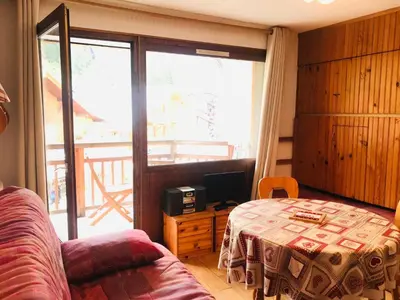 a room with a bed and a table and a window at Studio pour 2 près du centre de Samoëns - FR-1-629-77 in Samoëns