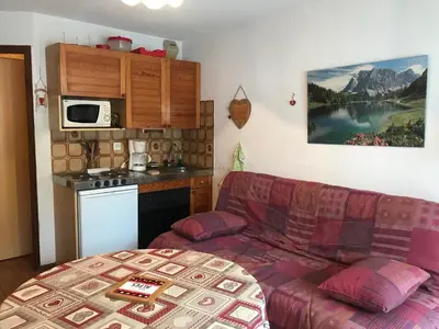 a living room with a couch and a kitchen at Studio pour 2 près du centre de Samoëns - FR-1-629-77 in Samoëns