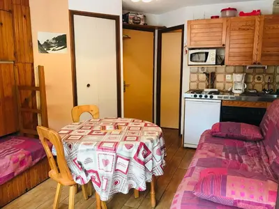 a room with a table and a kitchen with a stove at Studio pour 2 près du centre de Samoëns - FR-1-629-77 in Samoëns