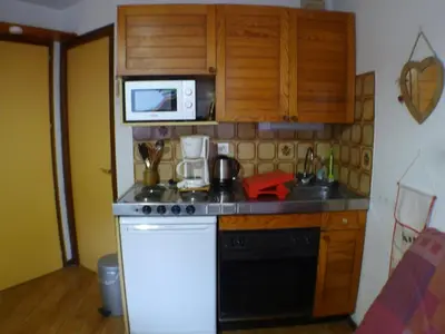 a kitchen with a stove and a microwave at Studio pour 2 près du centre de Samoëns - FR-1-629-77 in Samoëns