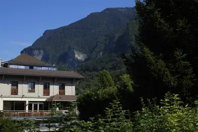 a house with a mountain in the background at Best Western Plus Pays du Mont Blanc in Sallanches
