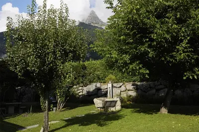 a bench in a yard with a mountain in the background at Best Western Plus Pays du Mont Blanc in Sallanches