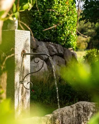 a stone bench with a water hose attached to it at Best Western Plus Pays du Mont Blanc in Sallanches