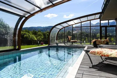 a swimming pool with an arched roof with a view at Best Western Plus Pays du Mont Blanc in Sallanches