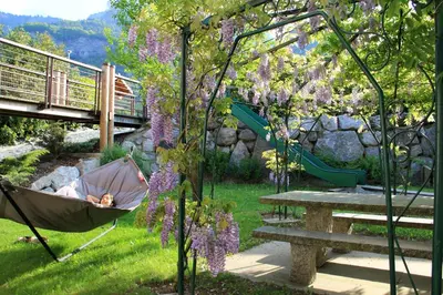 a child sleeping in a hammock in a garden at Best Western Plus Pays du Mont Blanc in Sallanches