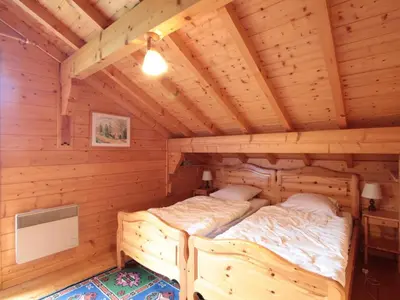 a room with two beds in a log cabin at Chalet 3 chambres calme, poêle à bois, proche piste et village, 6/8 pers, garage et parking - FR-1-572-243 in Les Carroz d'Araches