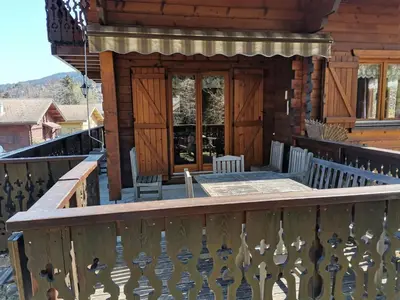 a porch of a log cabin with a wooden railing at Chalet 3 chambres calme, poêle à bois, proche piste et village, 6/8 pers, garage et parking - FR-1-572-243 in Les Carroz d'Araches