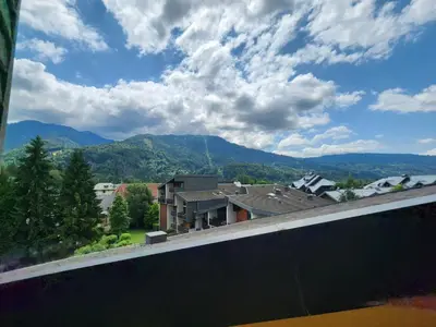 a view of a house with mountains in the background at Charmant appartement 2 pièces mezzanine, animaux admis, Samoëns - FR-1-629-53 in Samoëns