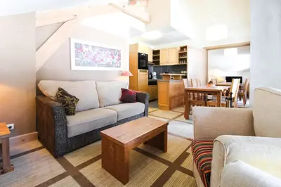 a living room with a couch and a table at Two internally connecting 2-bed apartments with shared private entrance in Flaine
