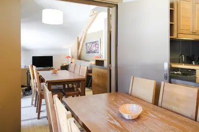 a kitchen and dining room with a table and chairs at Two internally connecting 2-bed apartments with shared private entrance in Flaine