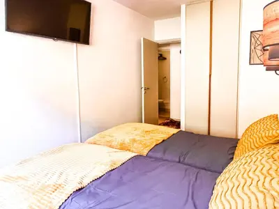 a bedroom with a bed and a flat screen tv at Large 2-Bedroom Apartment, Centre of Flaine Foret in Flaine