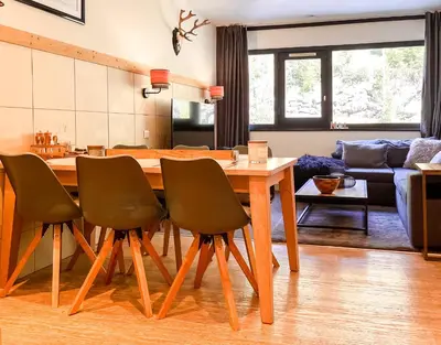 a kitchen and living room with a wooden table and chairs at Large 2-Bedroom Apartment, Centre of Flaine Foret in Flaine
