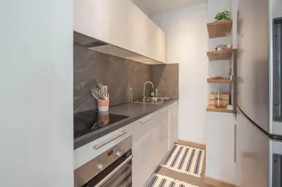 a kitchen with white cabinets and a sink at Les Aiguilles- Town centre luxury 2 bedroom apartment in Chamonix-Mont-Blanc
