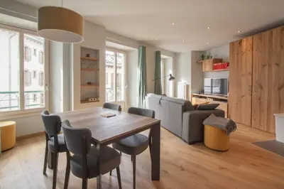 a living room with a dining room table and chairs at Les Aiguilles- Town centre luxury 2 bedroom apartment in Chamonix-Mont-Blanc